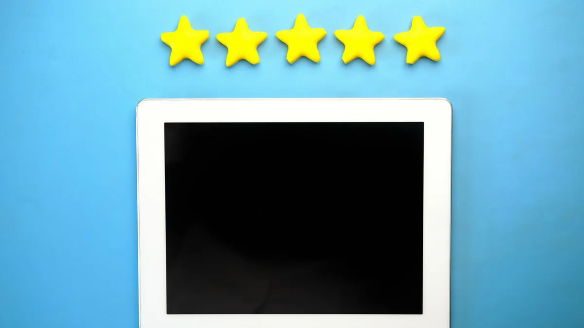 A hand holding a phone showing a five-star rating