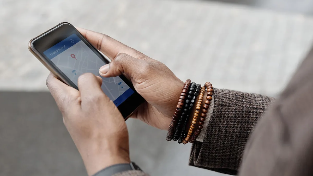 A person holding a phone open to Google Maps on a city street